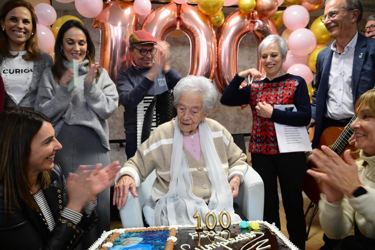 Apagando, ayer en el centro de día, la vela de los 100 años en la tarta.