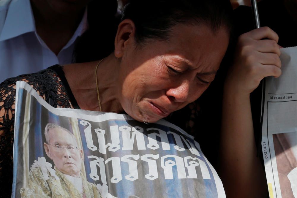 Una mujer llora mientras espera a que el cuerpo del rey Bhumibol Adulyadej de Tailandia sea trasladado al Grand Palace en Bangkok