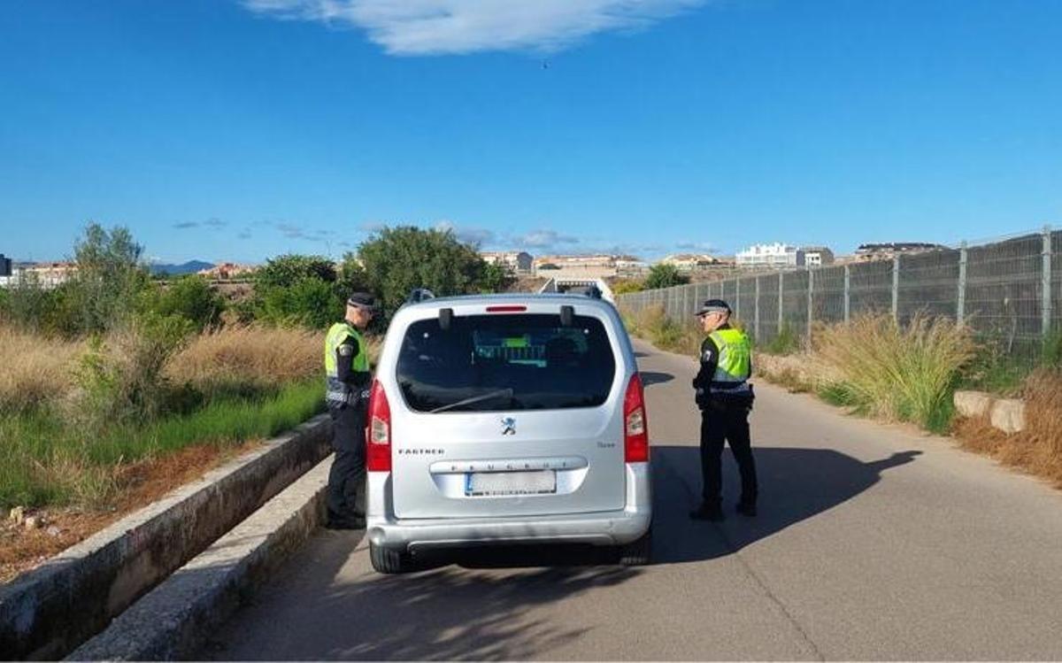 Dos agentes identifican e inspeccionan un vehículo que circula por el camino Almassora de Vila-real.