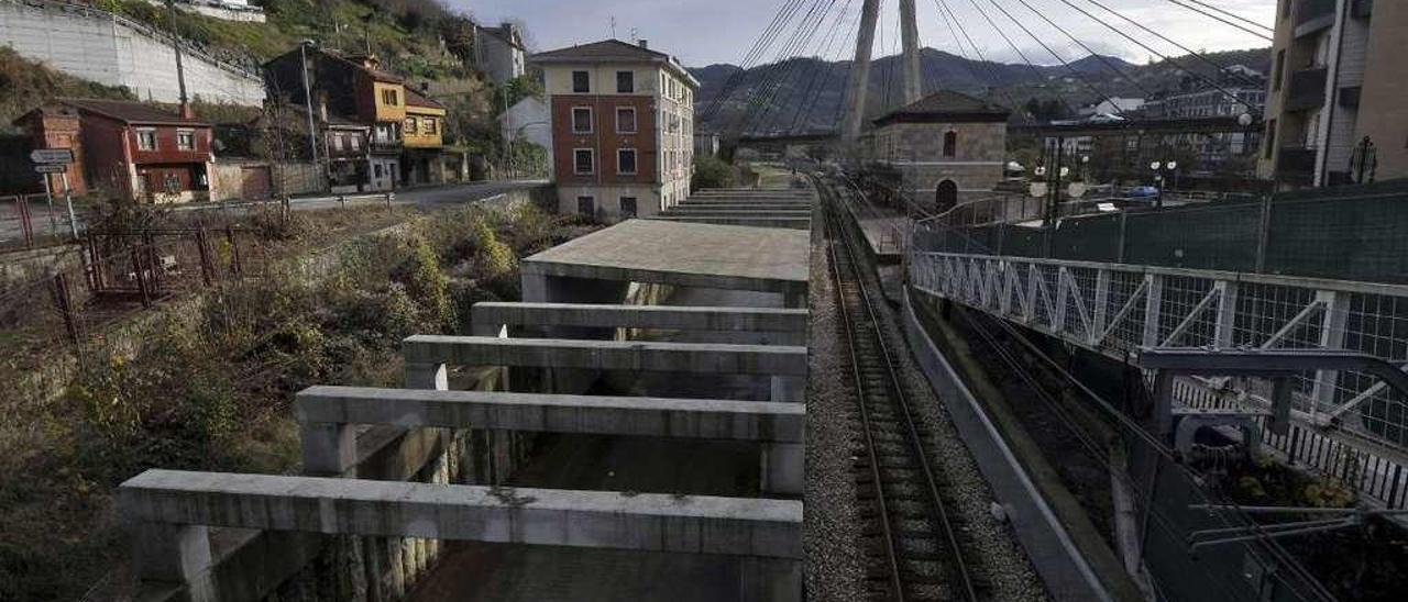 La rampa de acceso al falso túnel, junto a la vía actual, a la altura de la estación de Sama.