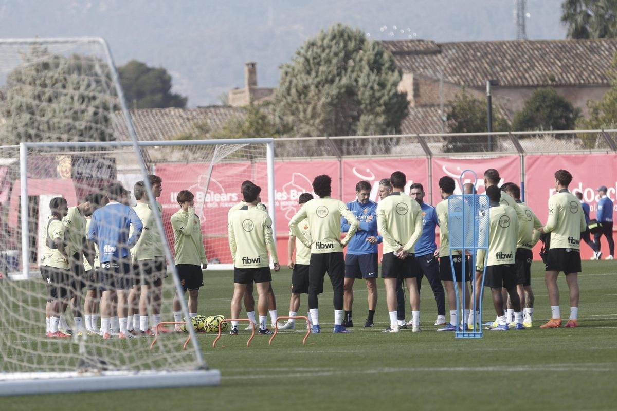 Germán Lux, junto a Martín Demichelis mientras el técnico da una charla a los jugadores.
