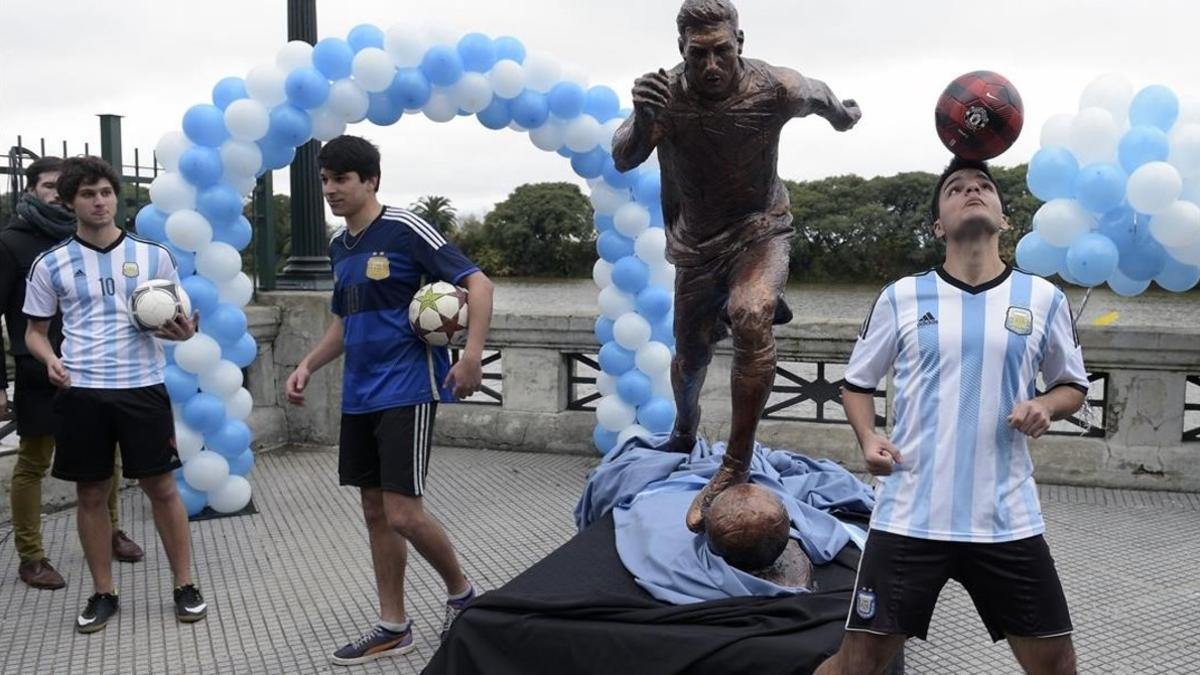 Unos chicos juegan delante de la nueva estatua dedicada a Messi en Buenos Aires.