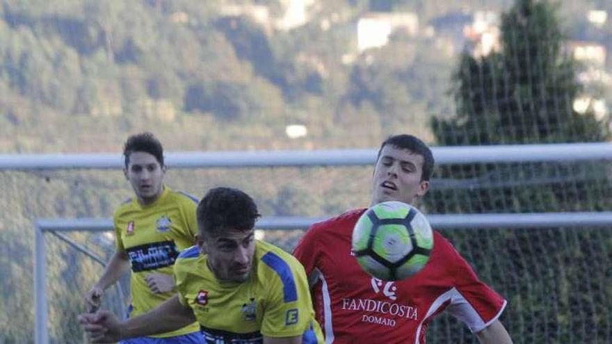 Un jugador visitante y otro del Domaio luchan por el balón. // S.Álvarez