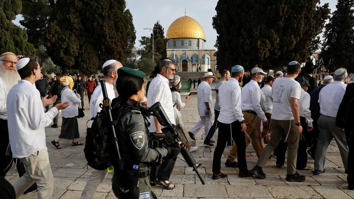 Fieles judíos cruzan la Explanada de las Mezquitas en Jerusalén ante la vigilancia de una militar del ejército de Israel, este sábado 9 de abril de 2023.