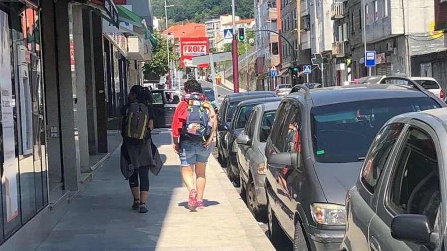 Dos peregrinos caminan por la Avenida de Vigo, en la parte baja de la parroquia de Chapela. // A.M.