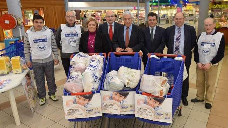 Responsables de Carrefour y el Banco de Alimentos con algunos de los productos donados.  // R. Vázquez