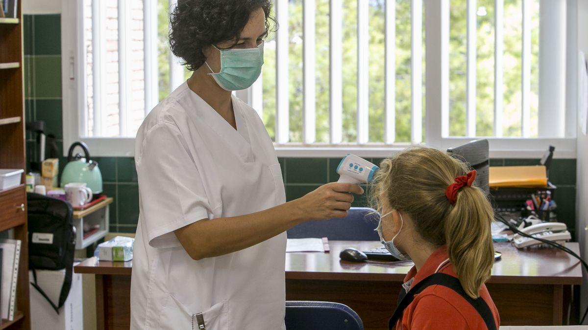 Una enfermera toma la temperatura a una niña