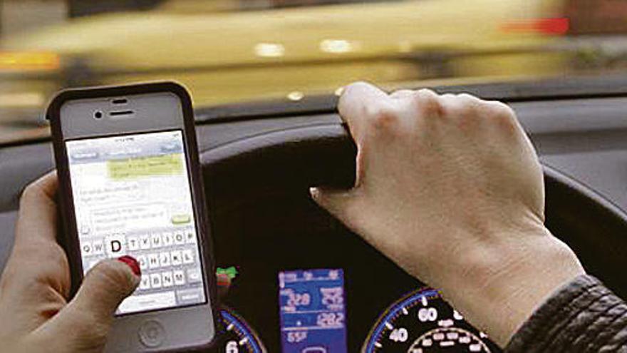 Una mujer, wasapeando al volante.