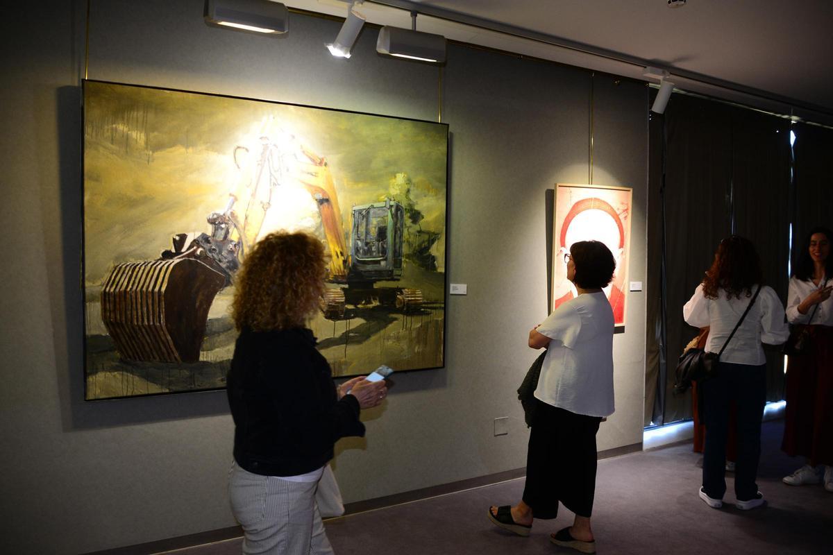 Varias personas observan una de las obras que concursa en la XXV Bienal Arte no Morrazo, en Cangas.