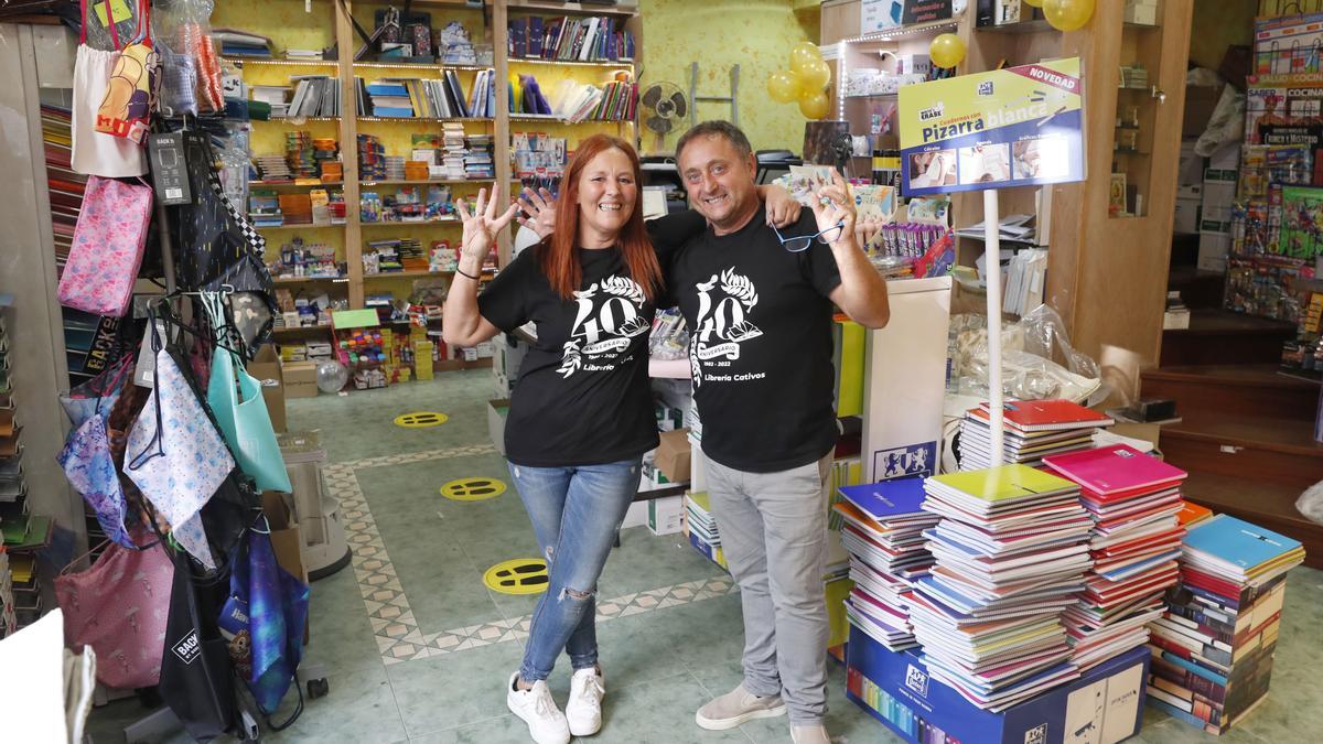 Los propietarios de la librería posan con camisetas conmemorativas del aniversario