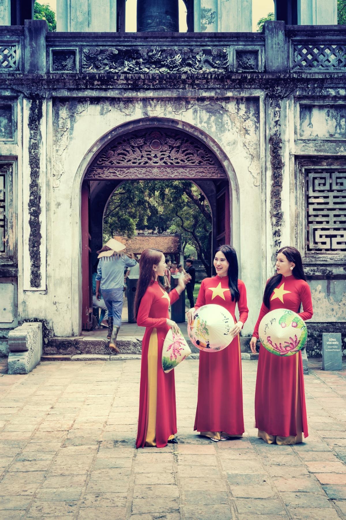 Vestidas con trajes tradicionales frente a la pagoda de Tran Quoc en Hanói
