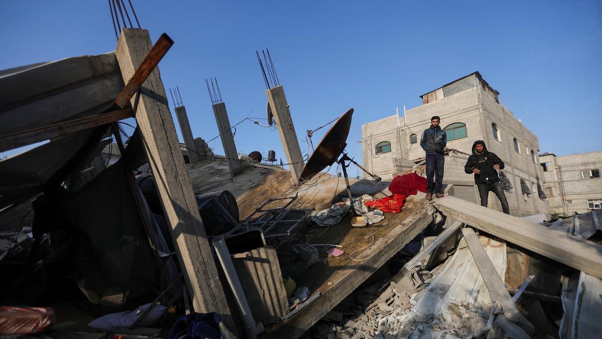 Palestinos inspeccionan el lugar de un ataque israelí contra una casa, en medio del conflicto en curso entre Israel y el grupo islamista palestino Hamas, en Rafah, en el sur de Gaza