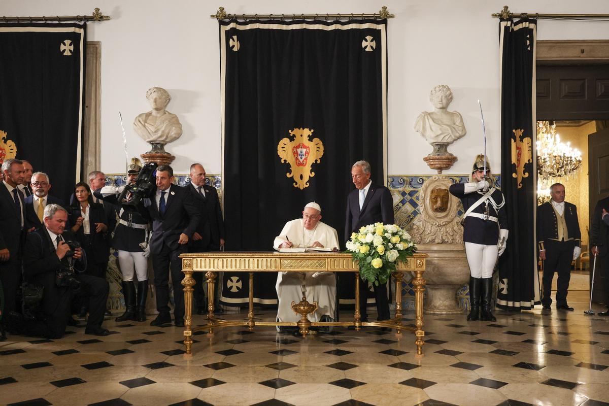 Lisbon (Portugal), 02/08/2023.- Pope Francis (C) signs the book of honor next to Portugal’s President Marcelo Rebelo de Sousa (R) during his welcome ceremony at Belem Palace in Lisbon, Portugal, 02 August 2023. The Pontiff is in Portugal on the occasion of World Youth Day (WYD), one of the main events of the Church that gathers the Pope with youngsters from around the world, that takes place until 06 August. (Papa, Lisboa) EFE/EPA/ANDRE KOSTERS / POOL