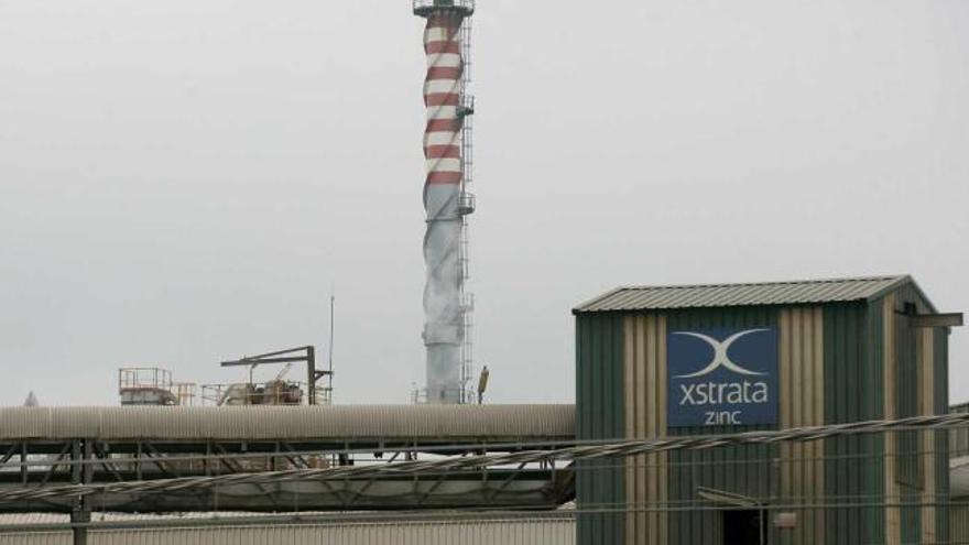 Una chimenea asoma del interior de la fábrica de Asturiana de Zinc en San Juan de Nieva.