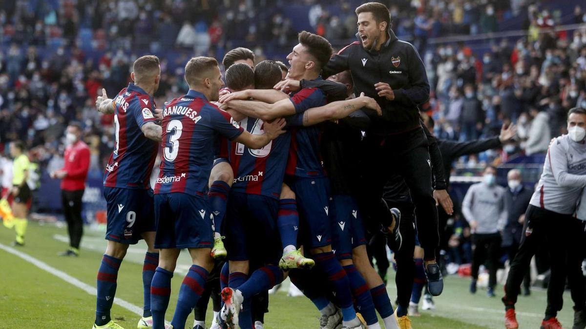 Alessio Lisci se abraza con los jugadores del Levante UD, en la piña posterior  al tanto de Soldado frente al Mallorca. | J.M.LÓPEZ