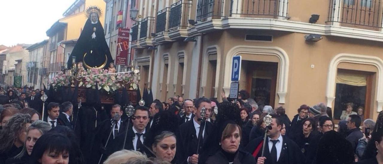 Damas de la Soledad con la Virgen al fondo en una procesión. |