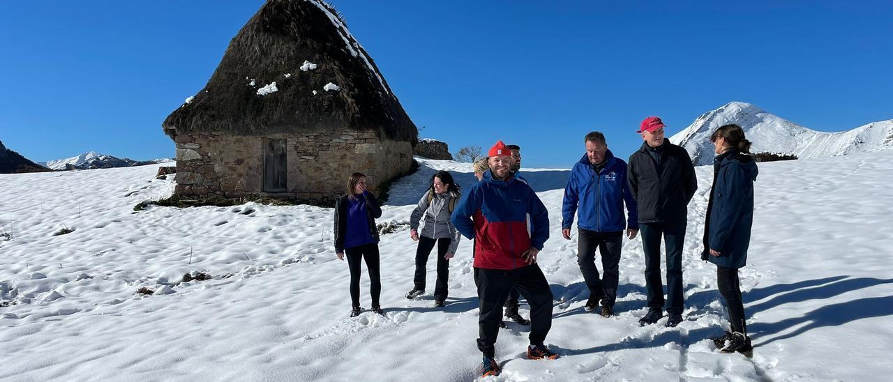 Turistas ingleses y españoles, junto a un teito, en las brañas somedanas de Saliencia.