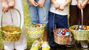 Ìmagen de archivo de unos niños recogiendo huevos de pascua.