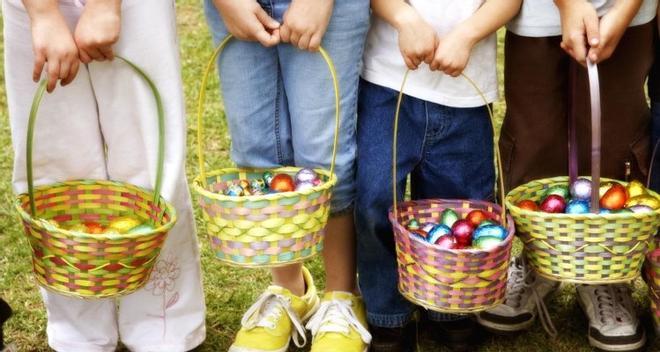 Ìmagen de archivo de unos niños recogiendo huevos de pascua.