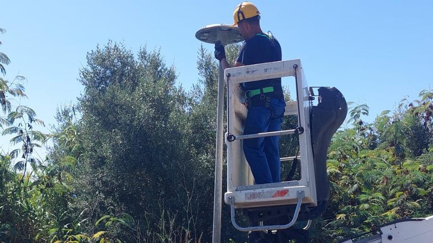 Un trabajador cambia una bombilla convecional por otra LED