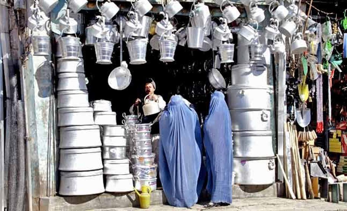 Un parell de dones afganeses compren estris domèstics en un lloc d’Herat (Afganistan). Segons diverses informacions, malgrat el progrés aconseguit els els últims anys, l’economia afganesa continua depenent en gran mesura de l’ajuda estrangera, de l’agricultura i de les transaccions econòmiques amb països veïns.