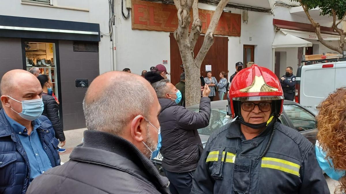 Un bombero informa a los vecinos.