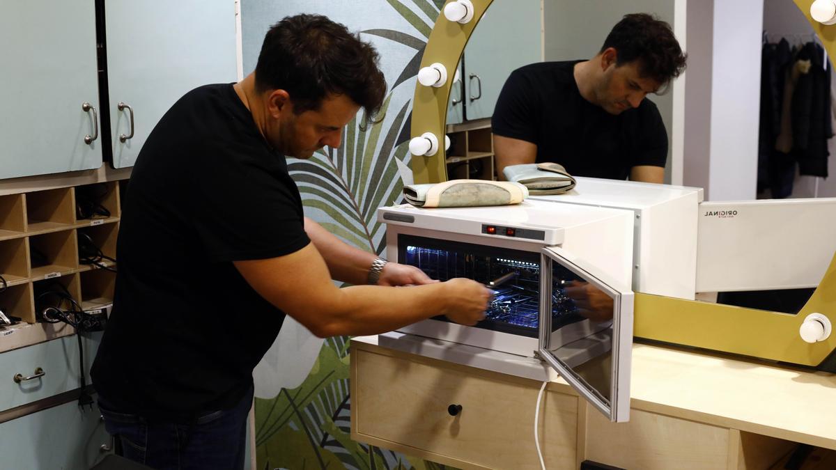 Oliver Calvo, de Oliver y Goretti, muestra la máquina ultravioleta con la que desinfectan las herramientas.