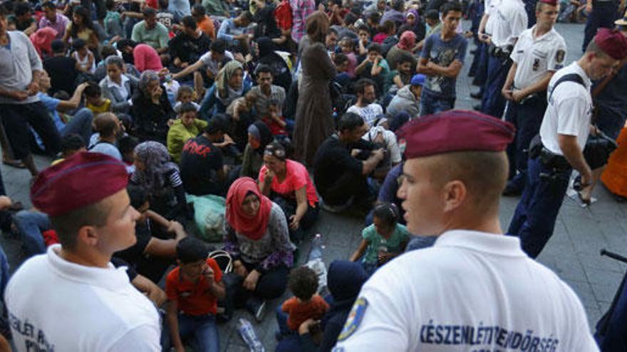 La Policía vigila a los inmigrantes fuera de la estación.