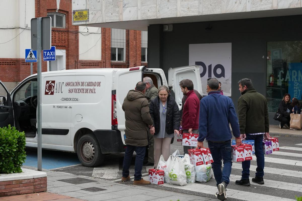 Miembros de la hermandad de la Vera Cruz de Badajoz llenan la furgoneta del comedor de San Vicente de Paúl con los alimentos recogidos en la mañana de este sábado.