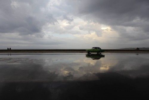 Un coche circula bajo la lluvia por El Malecón (La Habana)