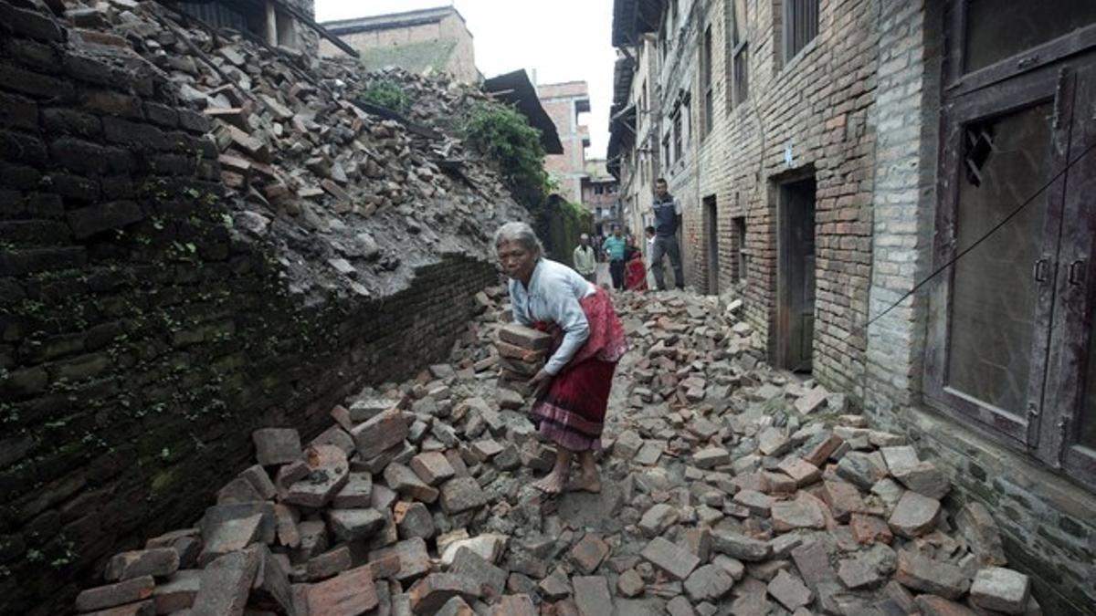 La nepalí Shuvadra Pathi busca sus pertenencias entre los escombros de su vivienda en Bhaktapur, a unos 13 kilómetros de Katmandú, este lunes.
