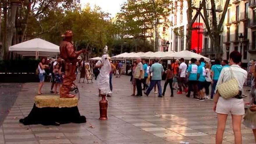 El hombre, vestido con una túnica en las Ramblas.