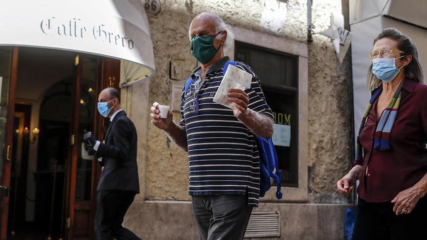 La gente camina fuera de la cafetería histórica de Antico Caffe Greco el primer día de la Fase 2 en Roma.