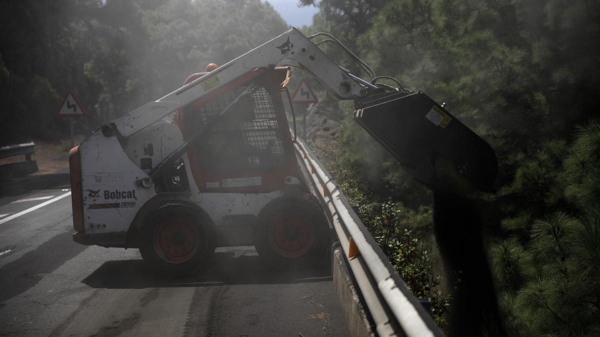 Una pala aparta la ceniza del volcán acumulada en una carretera de La Palma.