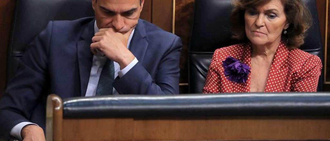 Sánchez y la vicepresidenta, Carmen Calvo, sentados ayer con semblante serio, en sus escaños del Congreso. // Reuters