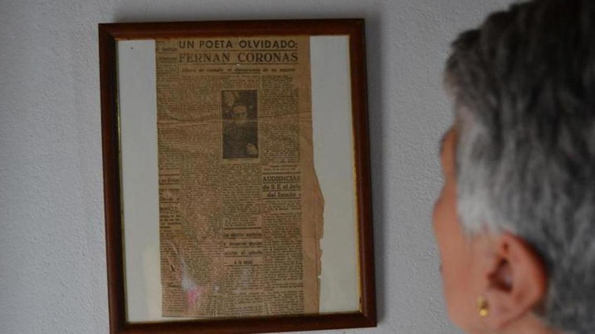Una mujer observa un antiguo recorte de prensa sobre Fernán Coronas.