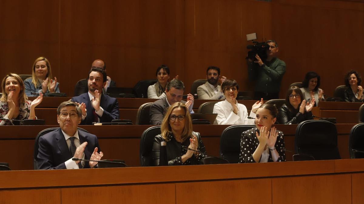 Los consejeros Arturo Aliaga, Mayte Pérez y Maru Díaz aplauden junto a la bancada socialista en un momento del pleno de las Cortes.