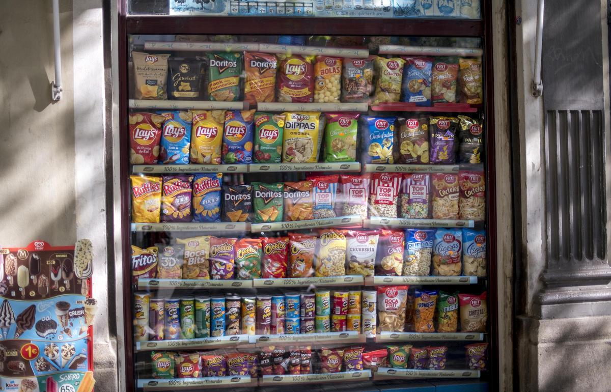 Escaparate con una gran variedad de bolsas de patatas fritas procesadas.