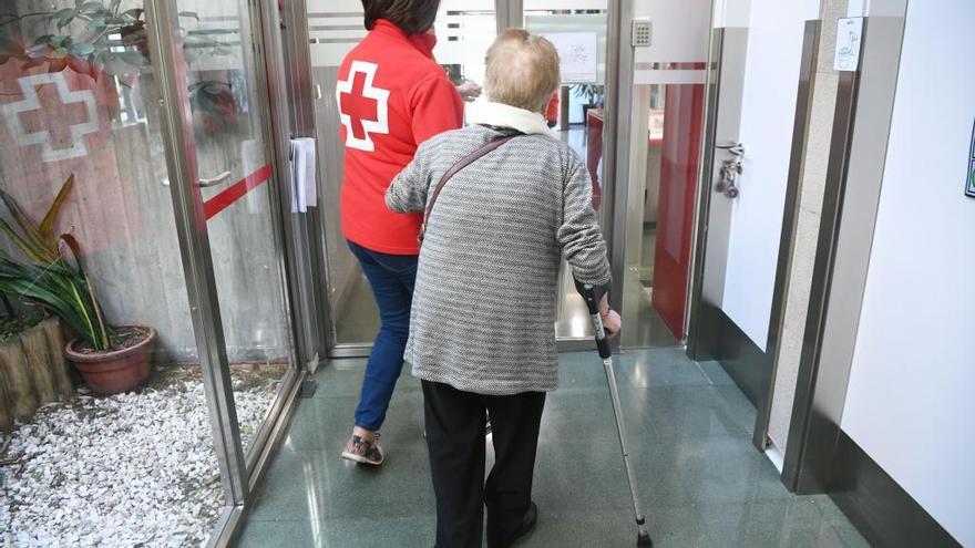 Una miembro de Cruz Roja y una mujer, en la sede de la entidad.