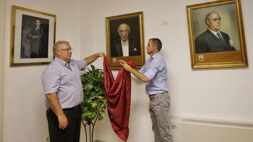 El alcalde Joan Monjo y el teniente de alcalde Martí Torres cuelgan el retrato de Juan March en la sala de plenos, a principios de mes.