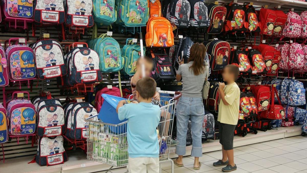 Una familia comprando libros y material escolar para la vuelta al colegio.