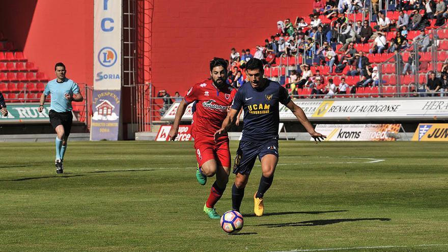 Unai Albizua, central del UCAM Murcia, disputa el balón con el atacante Asier Villalibre.