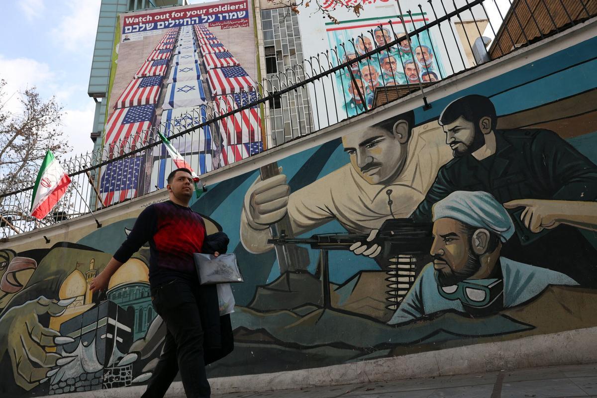 TEHRAN (Iran (Islamic Republic Of)), 29/01/2026.- An Iranian man walks next to a wall painting of Iranian soldiers (down) nearby an anti-US and Israel billboard (up) in Tehran, Iran, 29 January 2026. The US President Donald Trump on 28 January renewed threats of military action against Iran, saying 'time is running out for Iran to make a deal'. Tension has increased after anti-government protests in Iran erupted since 08 January 2026. (Protestas, Teherán) EFE/EPA/ABEDIN TAHERKENAREH