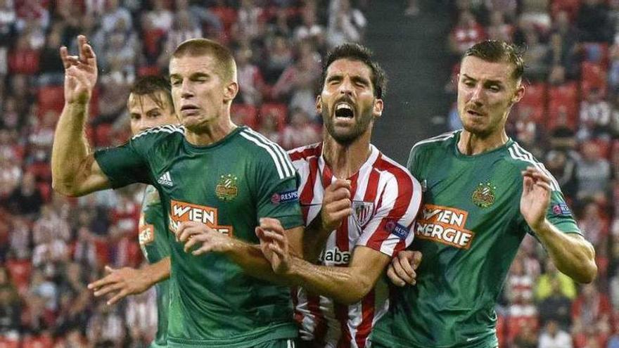 Raúl García, entre dos jugadores del Rapid de Viena.