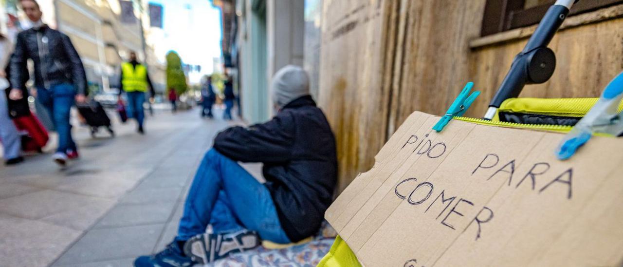 Una persona pide dinero recientemente en una de las principales calles comerciales de Alicante.  | DAVID REVENGA