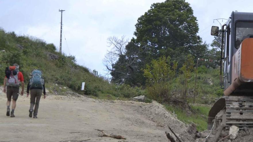 Dos peregrinos caminan por los desmontes del AVE en Aciberos.