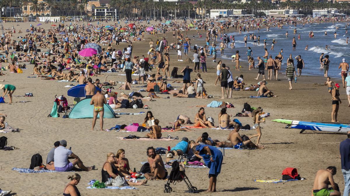 Bañistas disfrutan del día de Todos los Santos en la playa de la Malva-rosa.