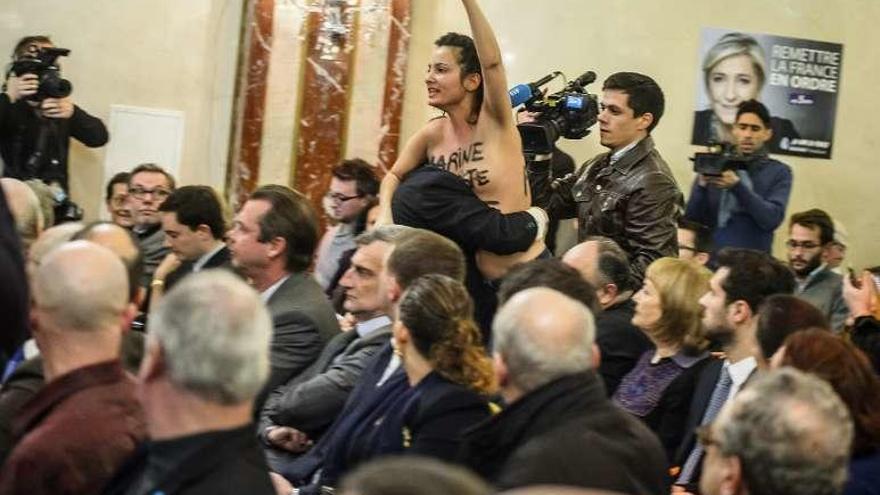 Una militante de Femen interrumpe un acto de Le Pen en París. // Efe
