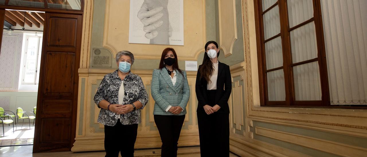 De izquierda a derecha, Pilar Vera, Cristina Roca y María Suárez Alemán, ante el cuadro ‘Contra el Olvido’ en la sede rectoral de la ULPGC .