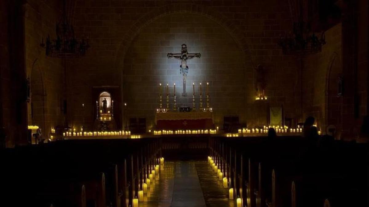 La nave y el altar de la iglesia de Sant Bertomeu, iluminados con cientos de cirios